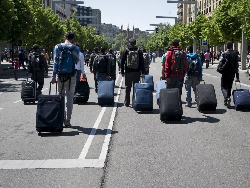 Jóvenes con maletas en el paseo de la Independencia de Zaragoza.