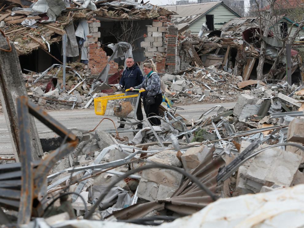Local residents walk along a street damaged during Ukraine-Russia conflict in the southern port city of Mariupol, Ukraine April 19, 2022. REUTERS/Alexander Ermochenko UKRAINE-CRISIS/MARIUPOL