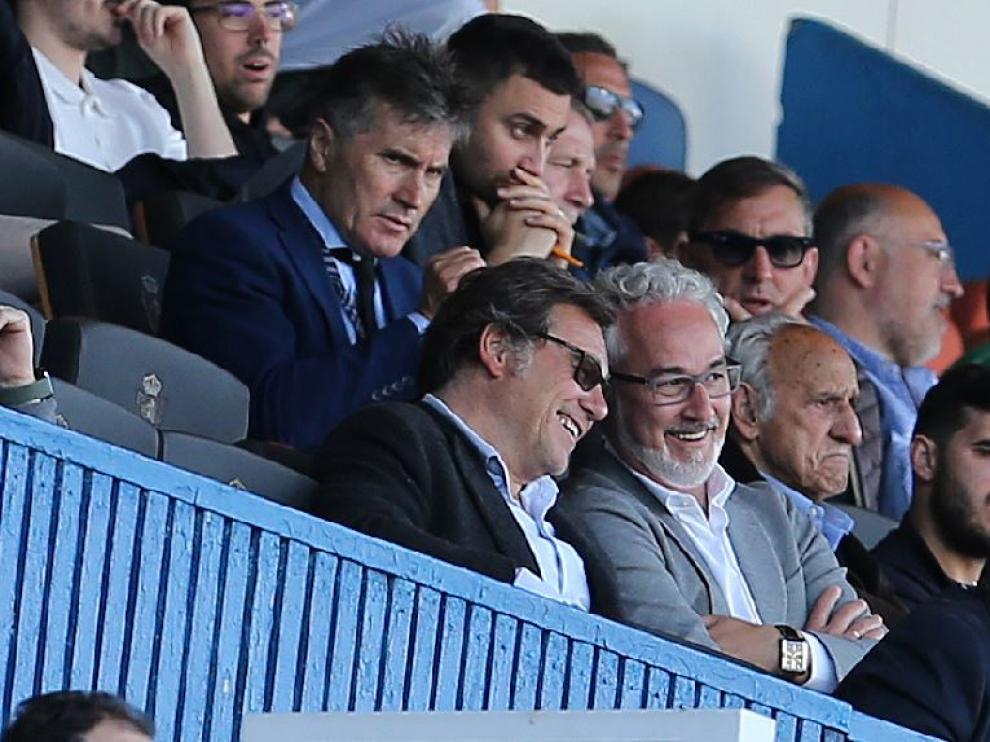 Raúl Sanllehí, con gafas de sol oscuras, sonríe en amistosa charla con Miguel Montes Torrecilla, actual director deportivo del Real Zaragoza, este domingo en el palco de autoridades de La Romareda en el partido ante el Burgos.
