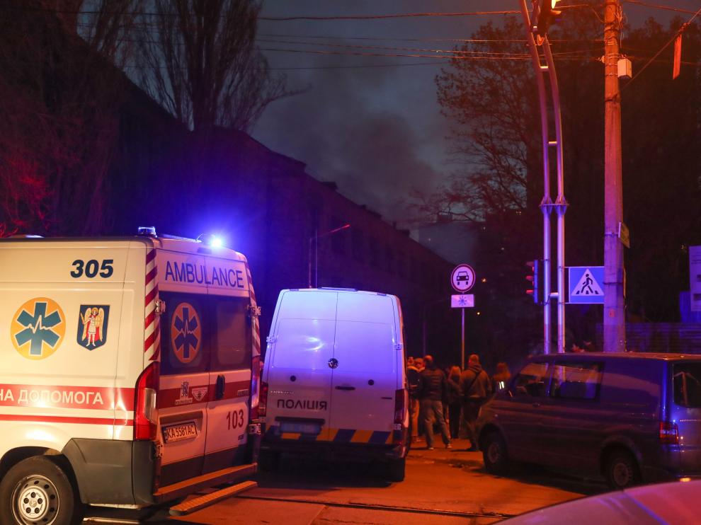 Miembros de los servicios de emergencia acuden al lugar de un ataque con misiles al centro de Kiev.