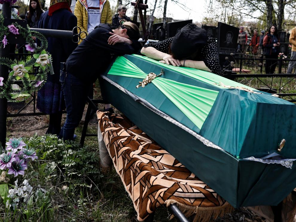 People mourn at the cemetery in Myrots'ke near Bucha