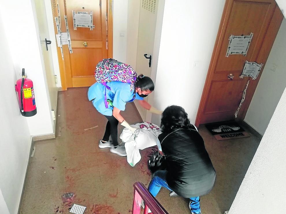 Dos trabajadoras de una empresa de limpieza retiraban este miércoles sábanas ensangrentadas dejadas por el 061