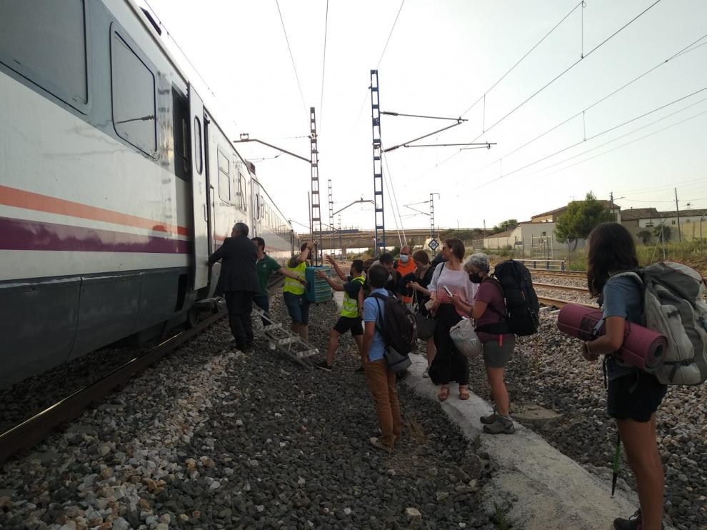 Los viajeros descienden del tren averiado este martes por la tarde a las afueras de Tardienta.