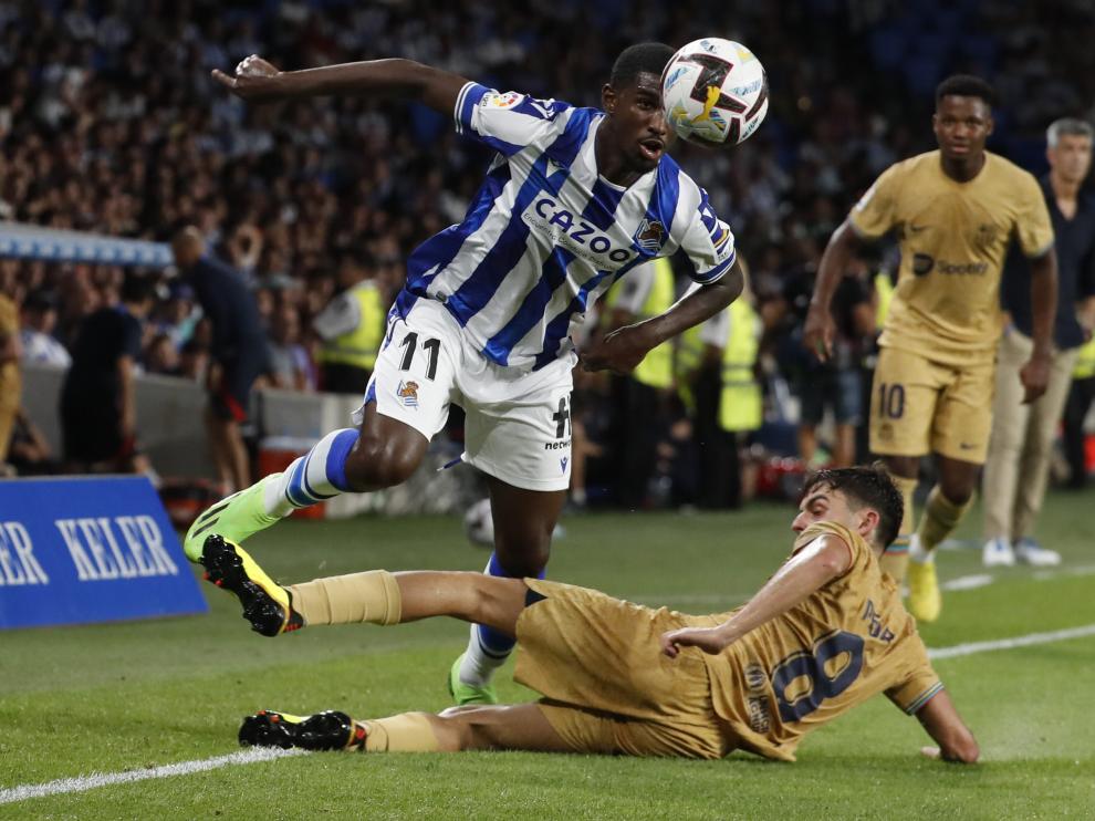 El delantero de la Real Sociedad Aleksander Isak (i) escapa de Pedri, del FC Barcelona, durante el partido de liga de este curso