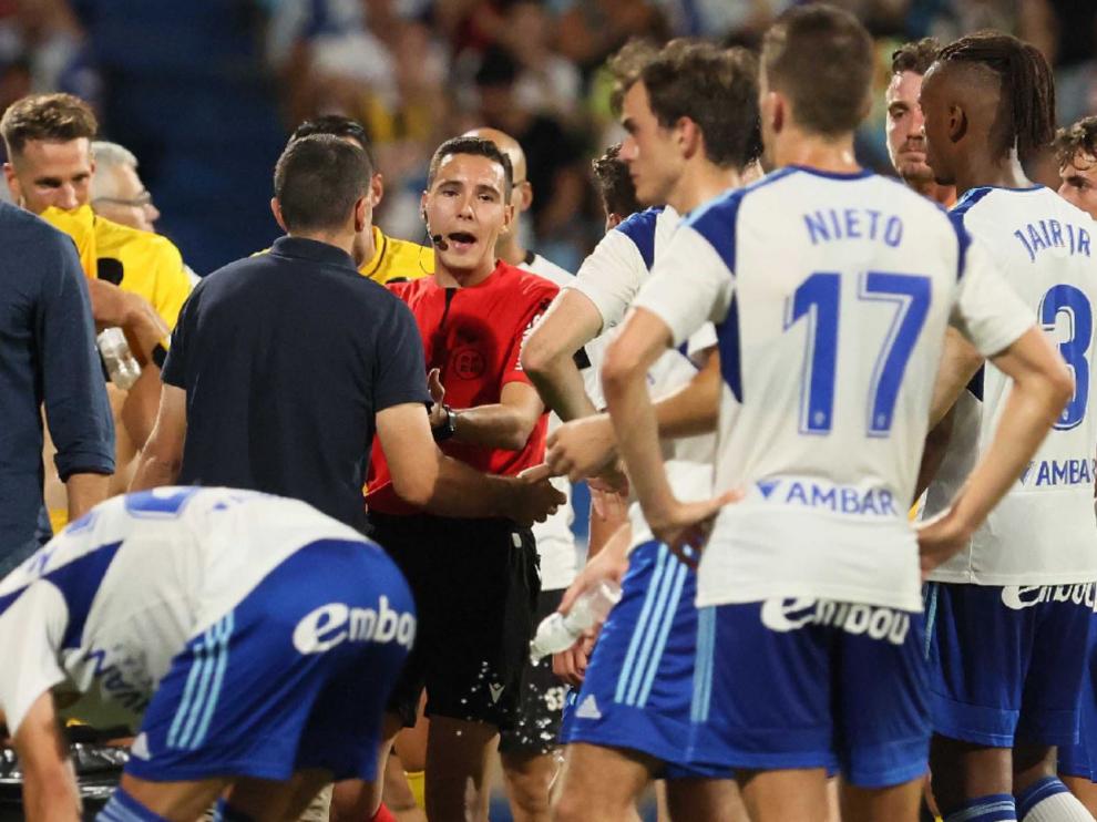 Los jugadores del Real Zaragoza y Carcedo hablan con el árbitro mientras se esperaba la validación o no del 1-0 de Simeone.