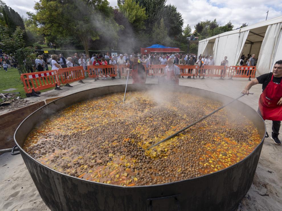 Uno de los cocineros da los últimos toques al monumental guiso de patatas con carne de toro.