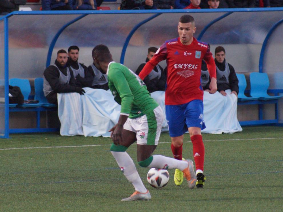 Carrasco conduce el balón ante la presión de un jugador del San Juan.