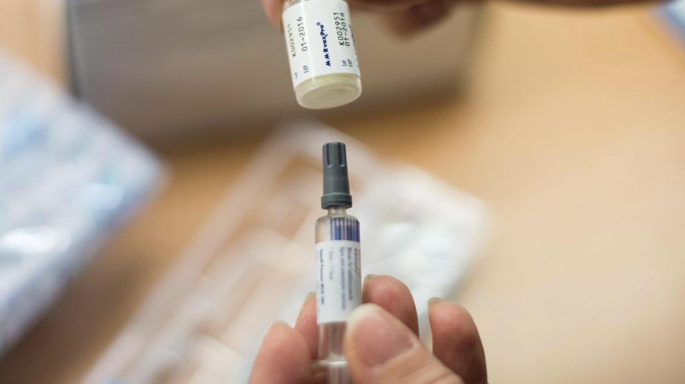 Una enfermera sostiene una vacuna contra el sarampión, la rubeola y las paperas