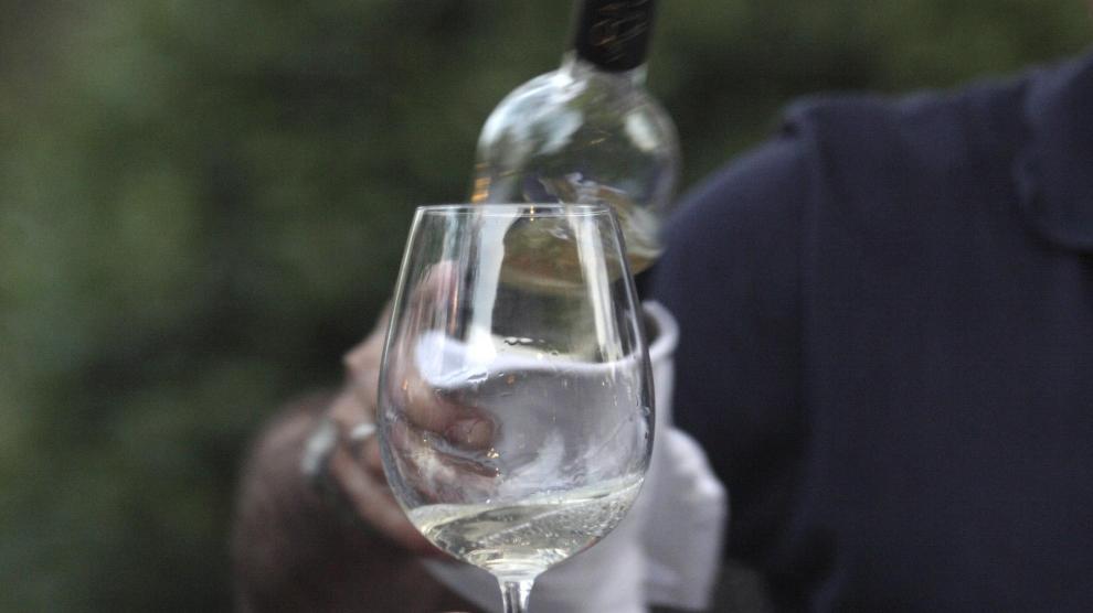 Sirviendo una copa de vino blanco.