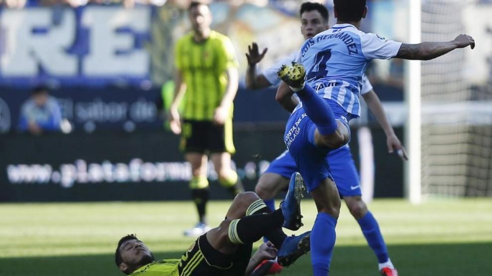 Un momento del último partido jugado por el Real Zaragoza, el de Málaga el 8 de marzo (0-1). En el suelo, Luis Suárez pelea con Luis Hernández.