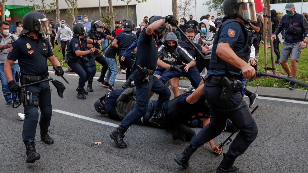 Miembros de la policía cargan contra un grupo de manifestantes que protestaban en favor de la Sanidad Pública y contra los confinamientos selectivos