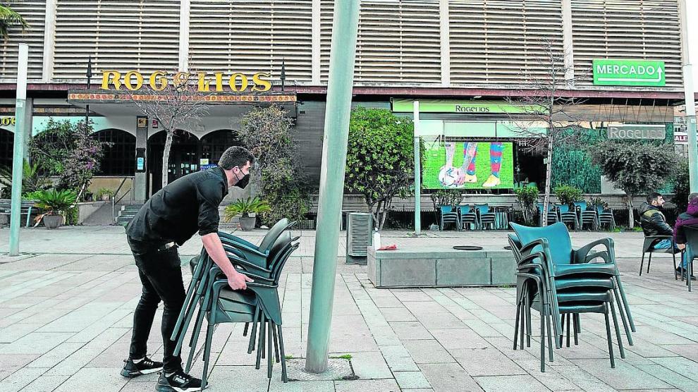 Un camarero recoge las sillas de una terraza en la zona de Romareda.