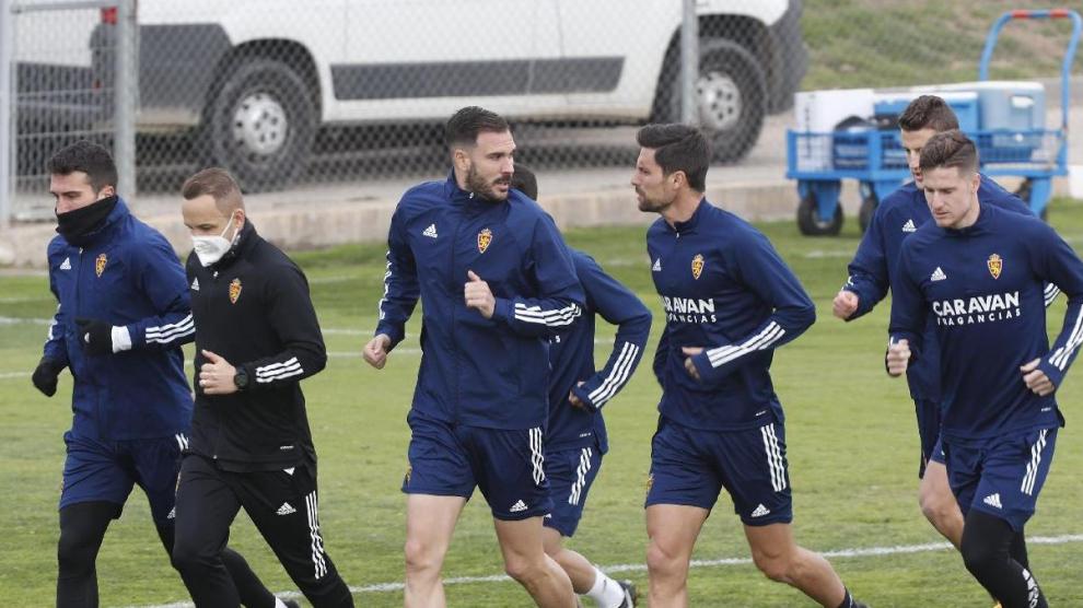 Zapater, primero a la izquierda con la cara cubierta del frío, ayer en el inicio del entrenamiento del Real Zaragoza.