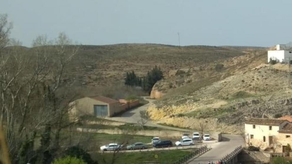Coches aparcados en la carretera sobre la presa romana que es Bien de Interés Cultural (BIC)