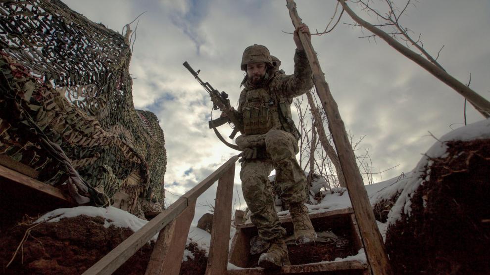 Un miembro del servicio de las fuerzas armadas de Ucrania camina en posiciones de combate cerca de la frontera con Rusia.