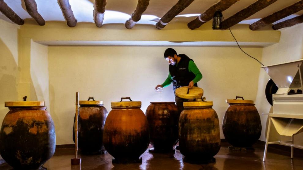 Víctor Clavería, comprueba el contenido de las tinajas de barro en las que fermenta el vino.