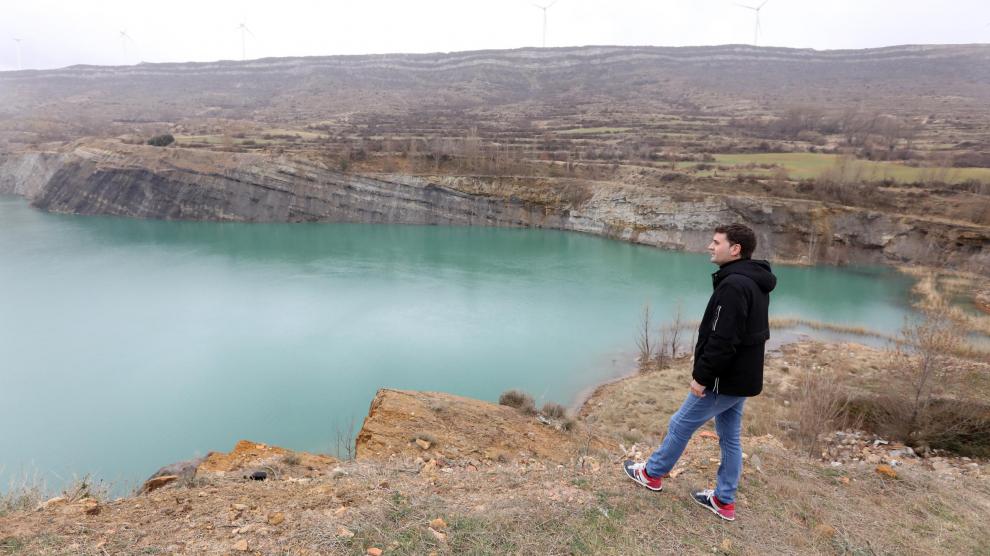 El alcalde, Ramiro Beltrán, junto a la laguna que se ha formado en el interior del desmonte minero abandonado