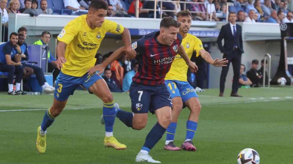 Gerard Valentín se marcha de dos jugadores rivales durante un partido en El Alcoraz.