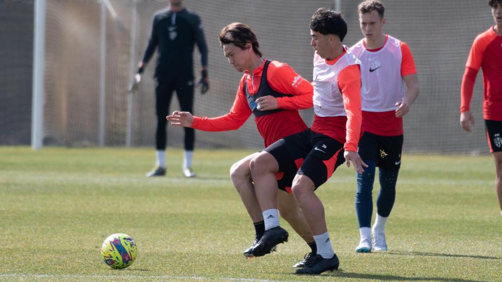 Kento Hashimoto trata de proteger el balón de la presión del futbolista del filial Jaime Escario.