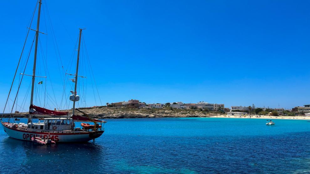 El velero Astral de la organización humanitaria española Open Arms anclado frente a una playa de Lampedusa.