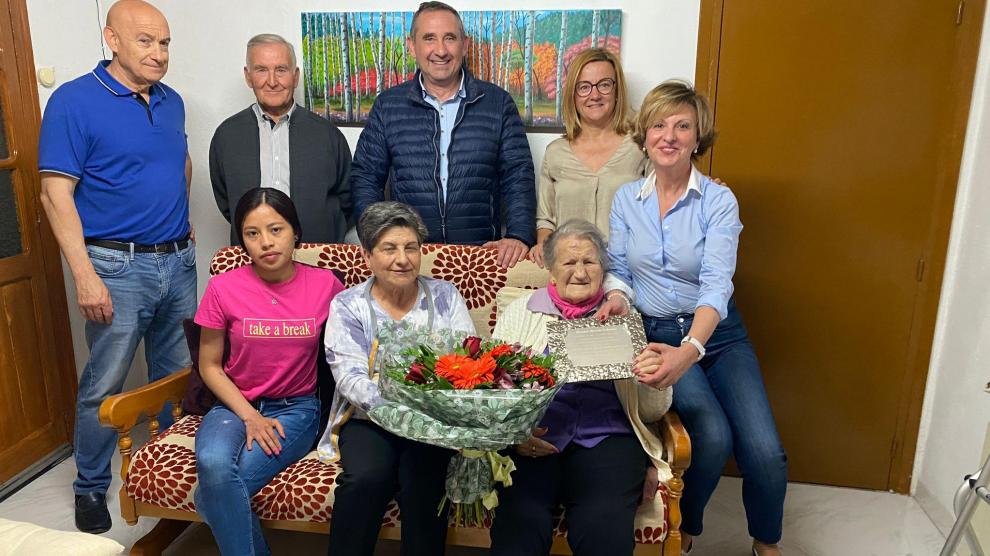 El alcalde Toño Ferrer y la teniente de alcalde, María Clusa, le entregan un ramo de flores y una placa.