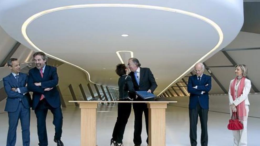 La presidenta de la Expo, Encarnación Vivanco, besa al de Ibercaja, Amado Franco, tras la firma.
