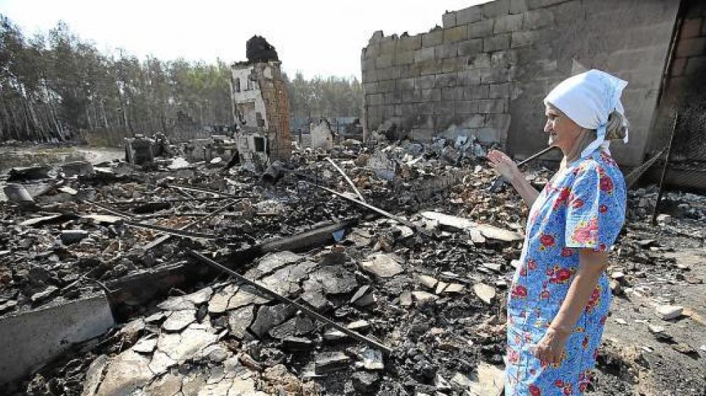 Una mujer mira su casa reducida a escombros por el fuego en Voronez, Rusia.
