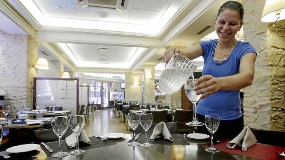 Mónica, camarera de la taberna Bílbilis, sirve agua del grifo en una copa.
