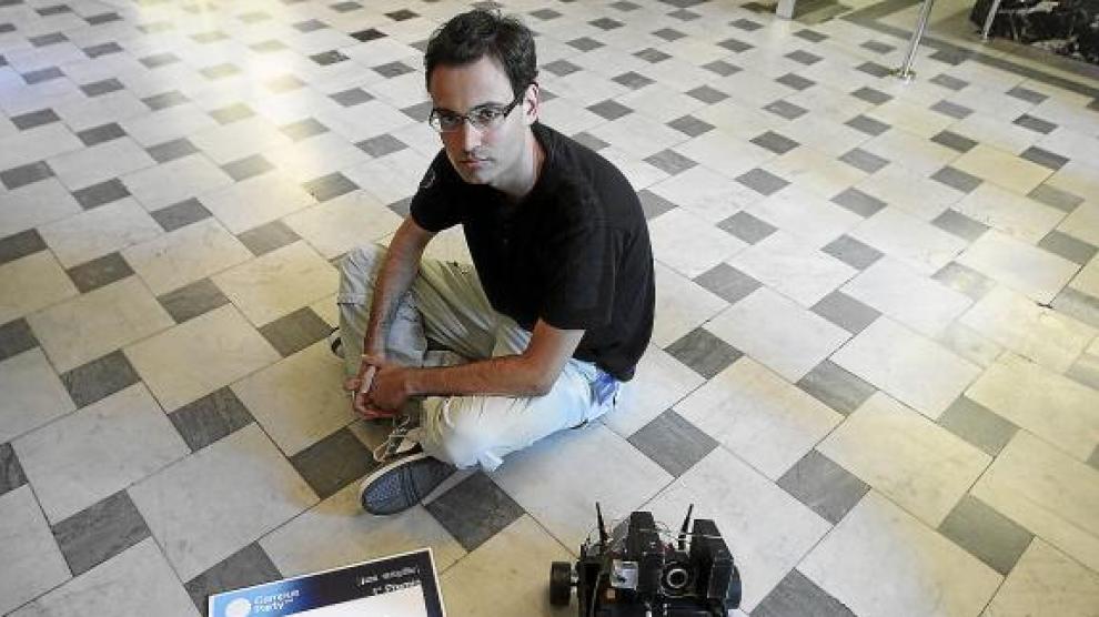 David Meléndez, sentado en el suelo con su robot y el diploma que ganó en Valencia.
