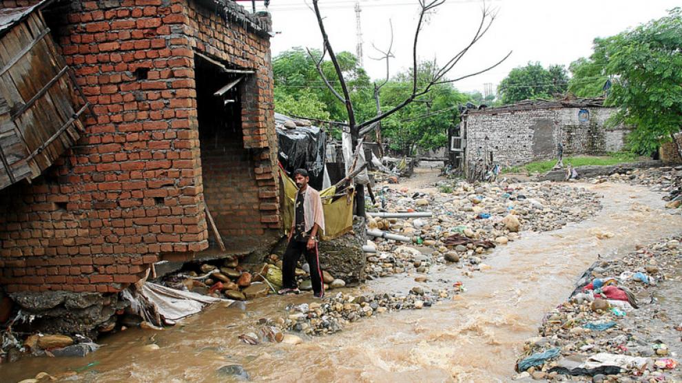 Un hombre observa una calle inundada junto a su casa durante las fuertes lluvias, ayer en Jammu.