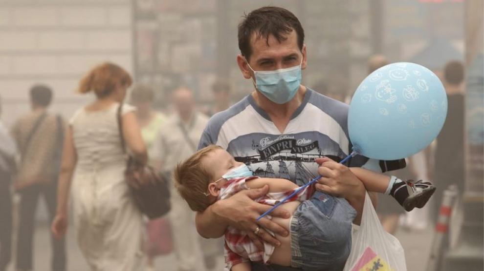 Un par de viandantes se protegen de la contaminación ambiental con mascarillas en el centro de Moscú