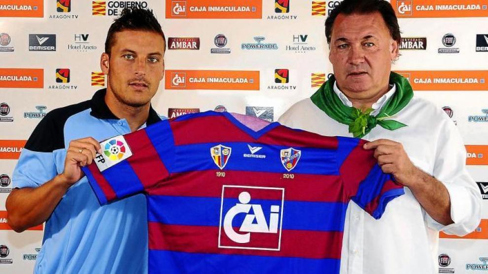 Marco Navas coge la camiseta del Huesca en compañía del vicepresidente de la entidad azulgrana, Agustín Lasaosa.