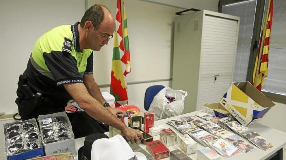 El oficial José Mª Salvador, con una pequeña muestra de los objetos incautados a los 'manteros'.