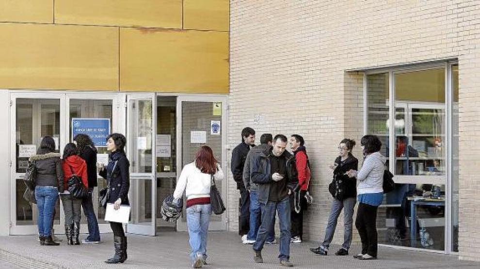 Jovenes estudiantes, a las puertas de un centro universitario, en Zaragoza.