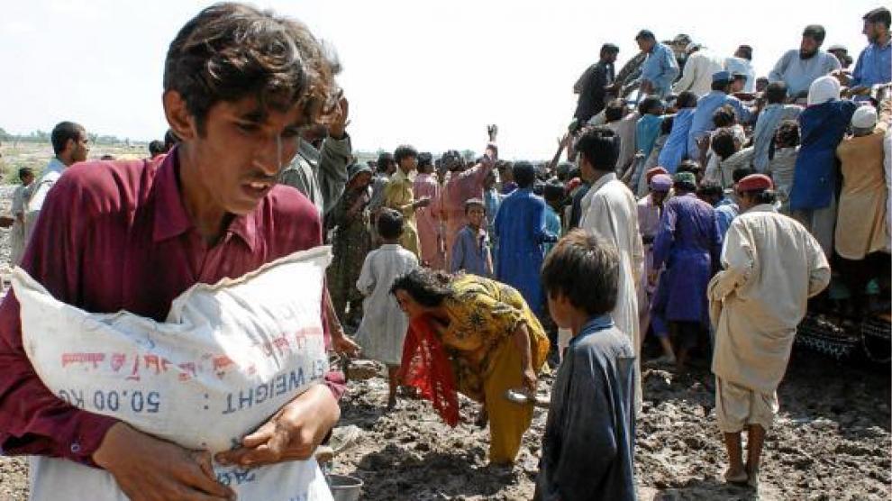 Víctimas de las inundaciones recogen la ayuda humanitaria en un campo de refugiados en Sukkur.