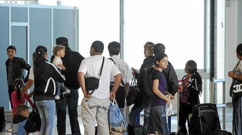 Un grupo de gitanos esperan para ser embarcados en un avión rumbo a Bucarest, ayer en Lyon.