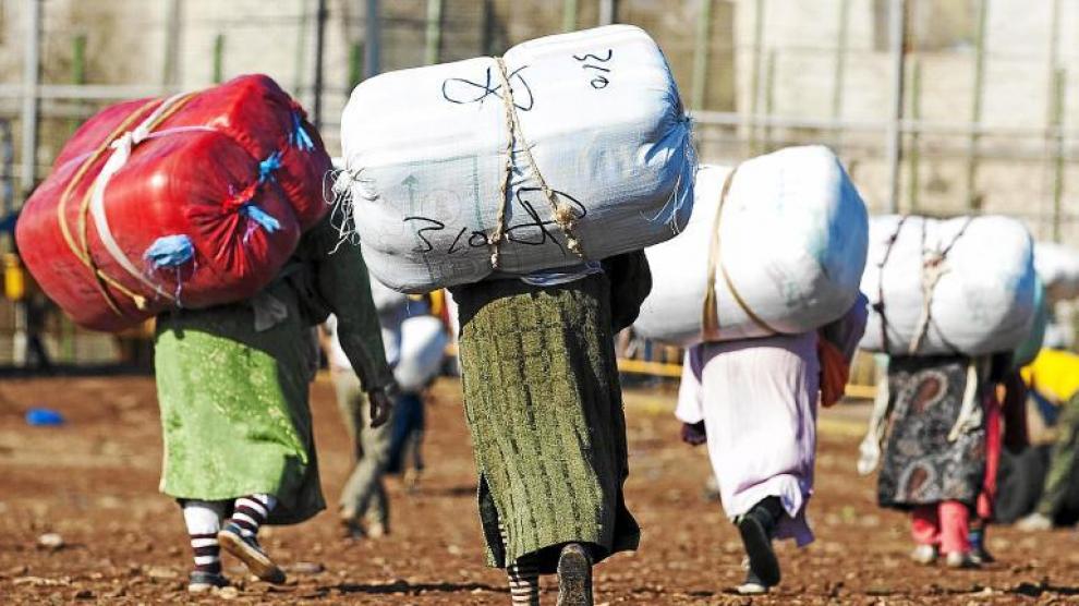 Numerosas porteadoras se dirigen hacia la frontera de Melilla con Marruecos, en el llamado Barrio Chino, ayer por la mañana.