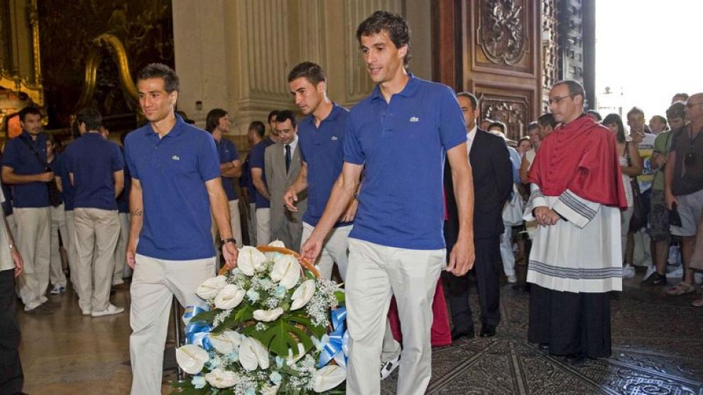 Ponzio, Jorge López y Gabi portan el centro de flores ofrecido a la Virgen del Pilar.