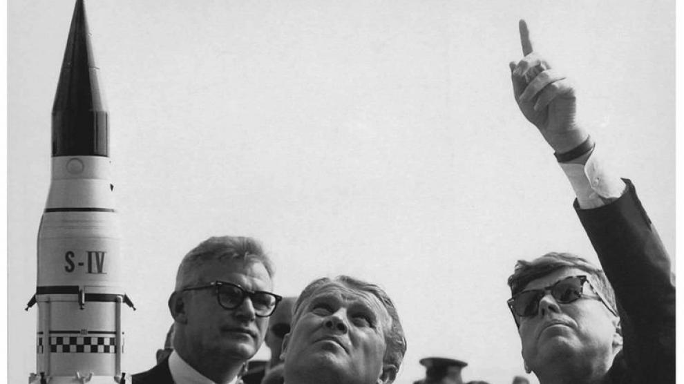científico alemán Wernher von Braun (2i) al explicarle al entonces presidente estadounidense John F. Kennedy (d) el sistema de lanzamiento de cohetes hacia Saturno