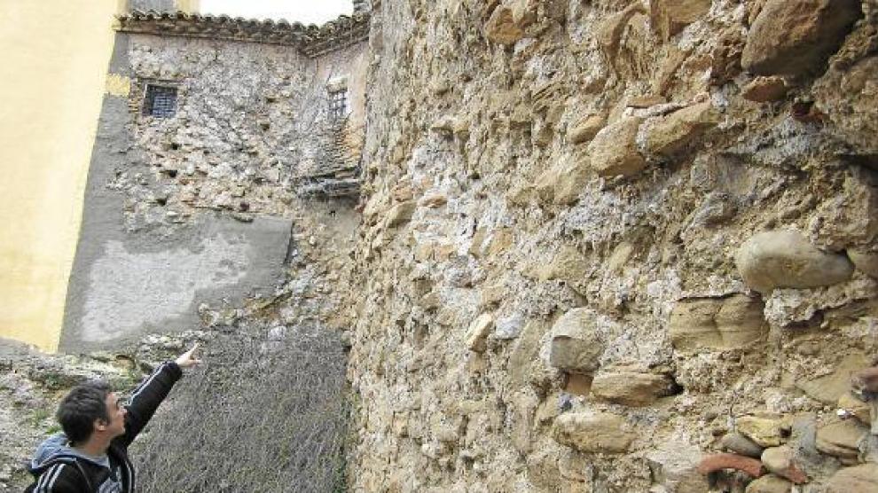 Un vecino señala el muro de la iglesia que provoca los desprendimientos.
