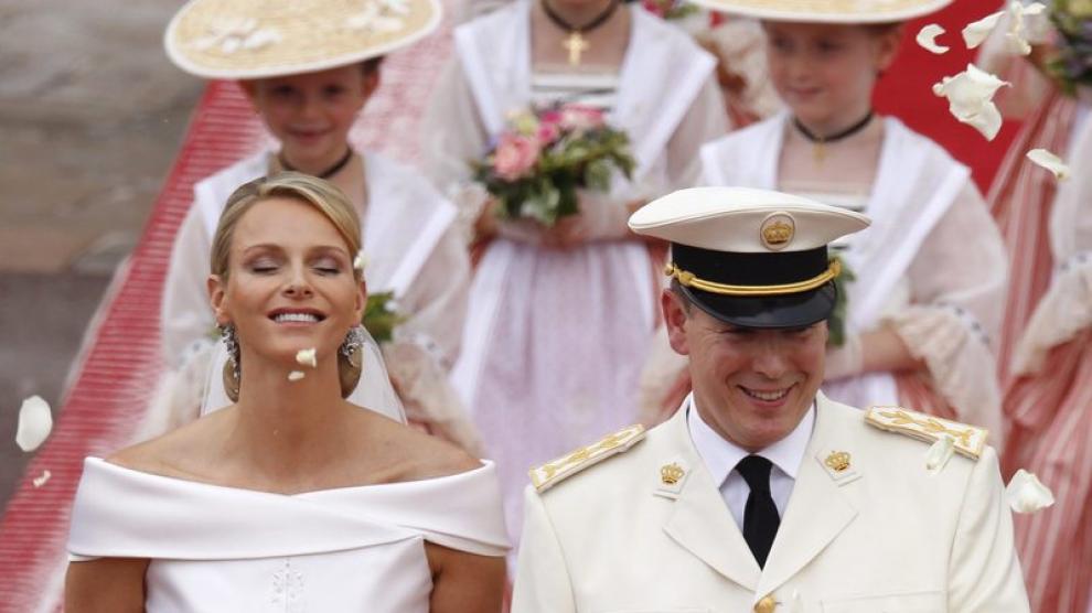 El príncipe Alberto II de Mónaco (d) y la princesa Charlene saludan a los invitados mientras abandonan el Palacio Real