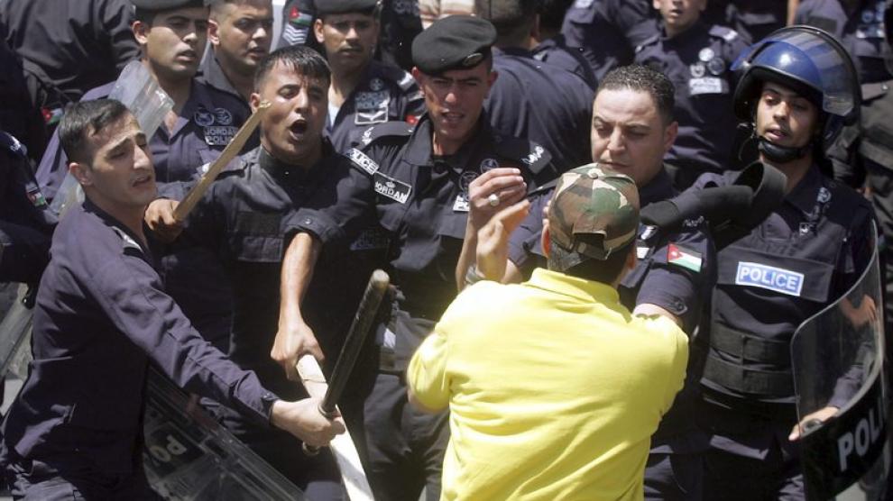Varios policías golpean a un manifestante durante las protestas.