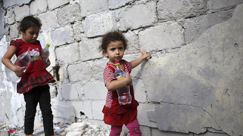 Dos niñas llevan botellas de agua en Gaza