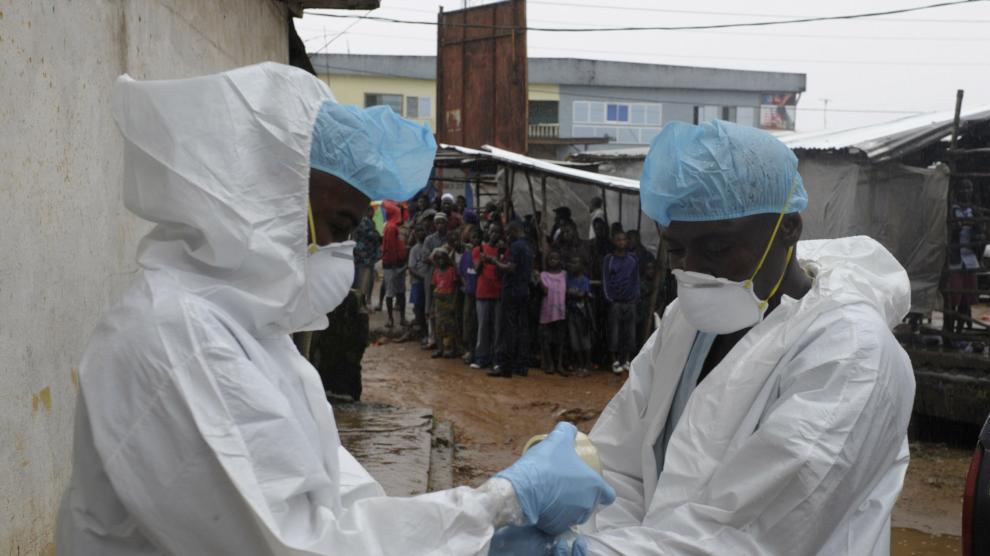 Trabajadores sanitarios se preparan para trasladar el cuerpo de un infectado por el virus del ébola en Monrovia