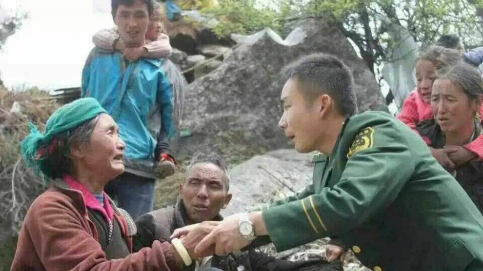 Un paramilitar tranquiliza a una mujer en la prefectura de Xinhua.