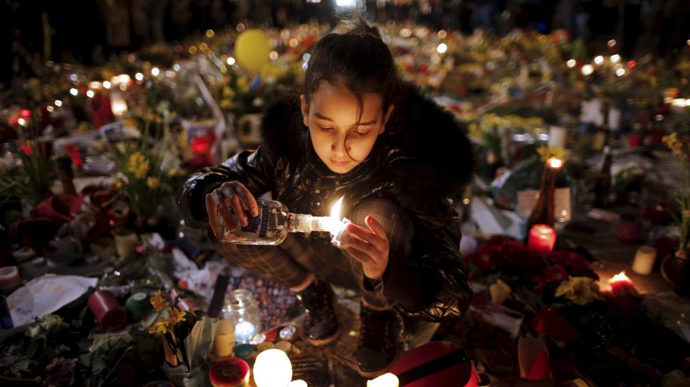 Una niña enciende una vela por las víctimas de los atentados del martes.