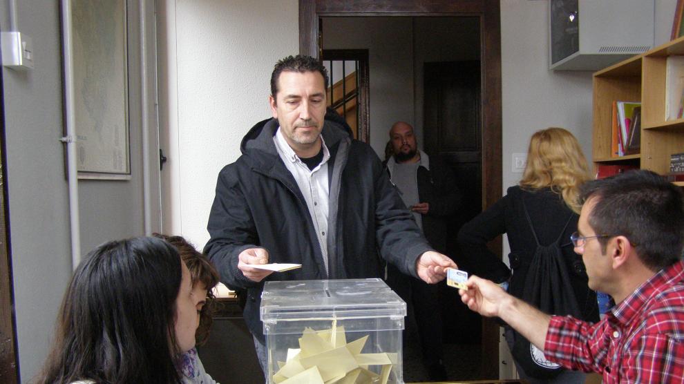 Un padre deposita su voto en el colegio público Joaquín Costa para decidir sobre la jornada escolar.