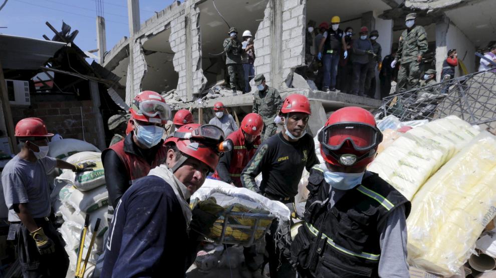 Miembros de los equipos de rescate trasladan a una víctima rescatada entre los escombros en Pedernales, Ecuador.