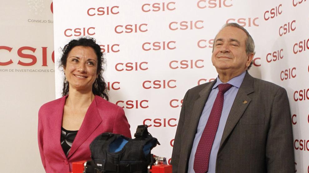 El presidente del CSIC, Emilio Lora, posa junto a la investigadora Elena García, que ha creado el exoesqueleto dirigido a niños con atrofia muscular espinal.