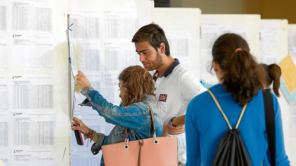 Dos personas consultan las listas de espera de los grados de la Universidad de Zaragoza, esta semana.